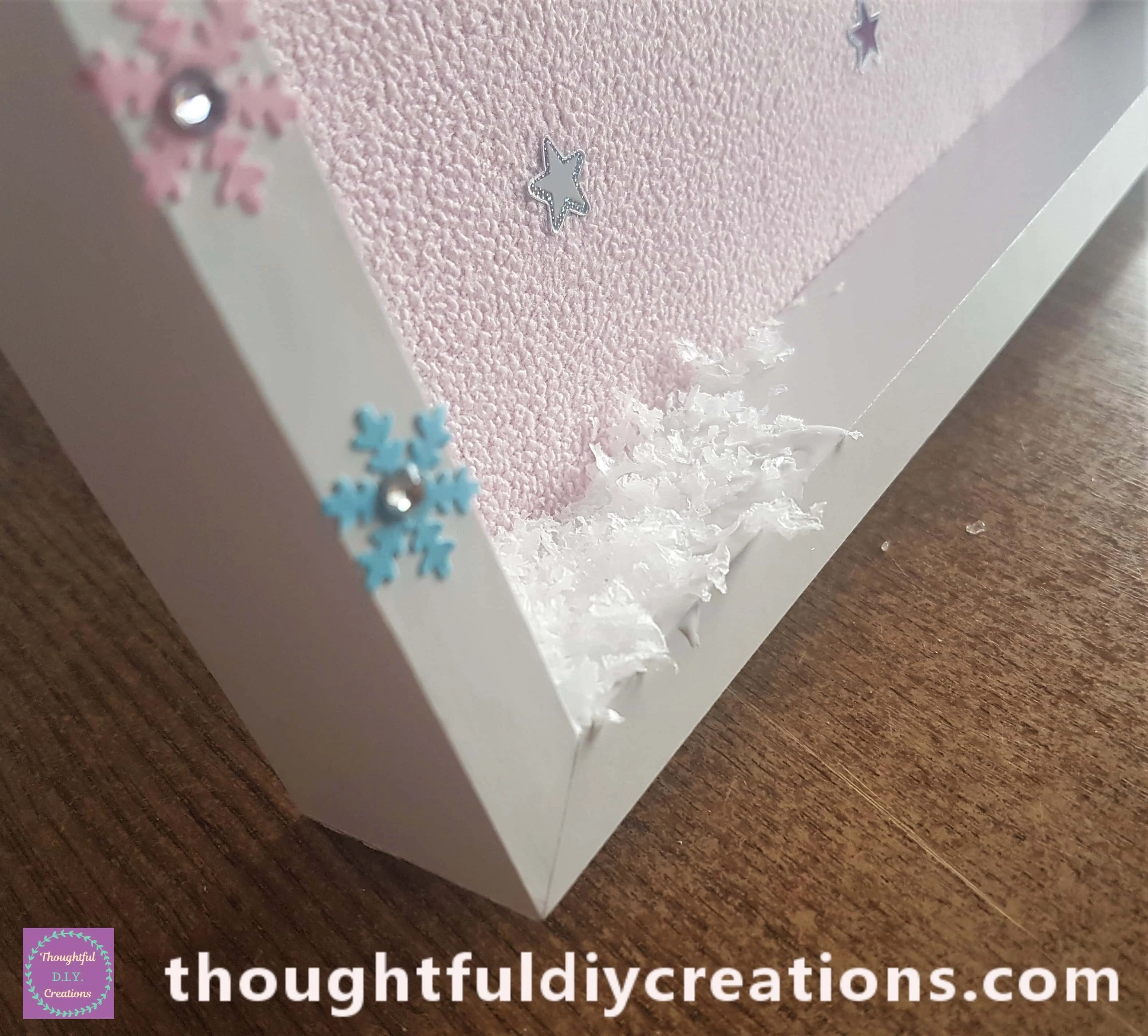 Mod Podge on the bottom part of the frame and added the snow confetti to it.