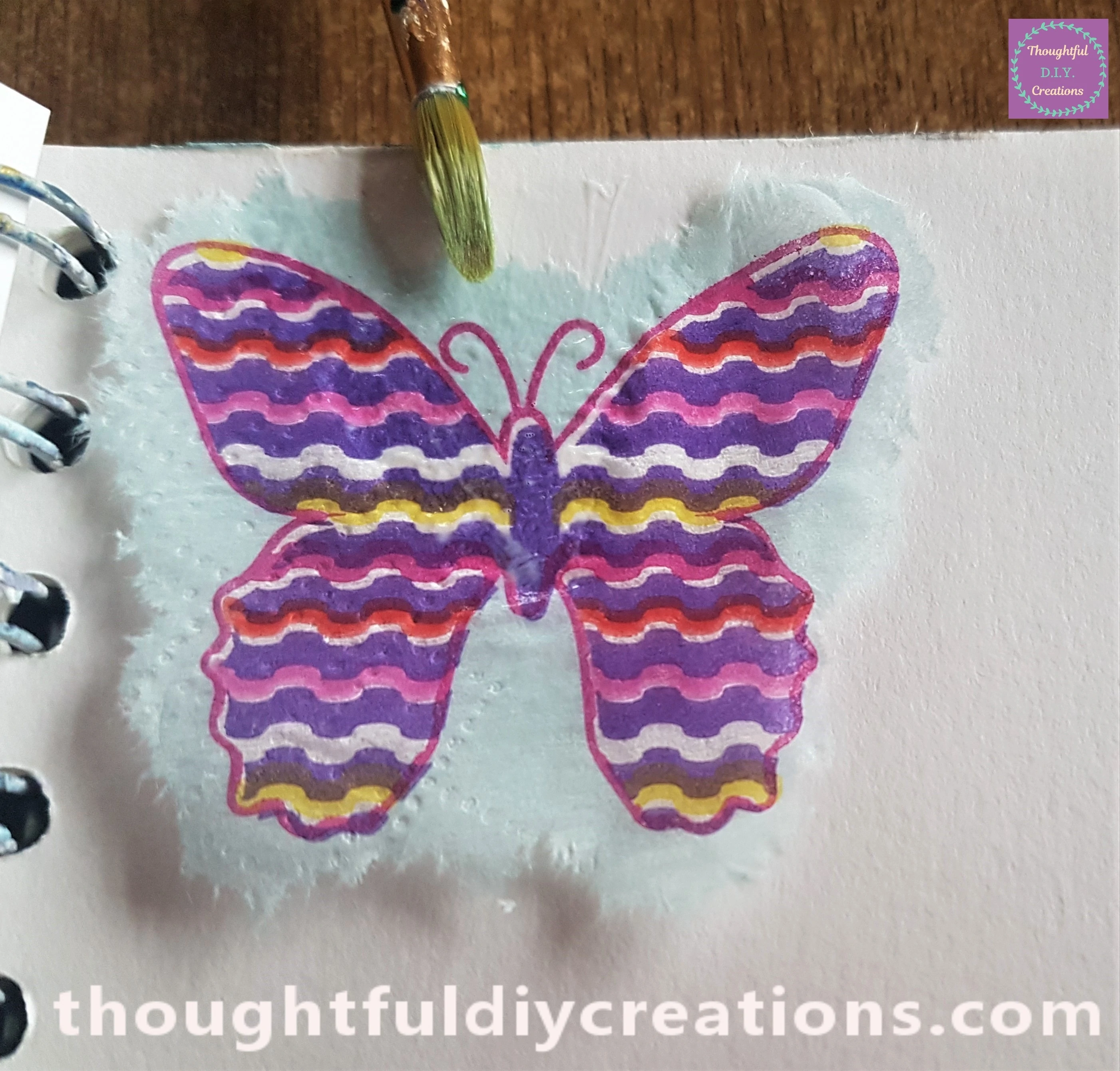 I put a butterfly on the top of the Page. I dipped the brush into the mod podge and gently brushed in onto the top mid-section of the butterfly.