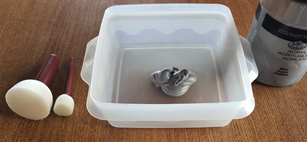 I poured some Paint into a plastic lid and got a large and small Sponge with handle.