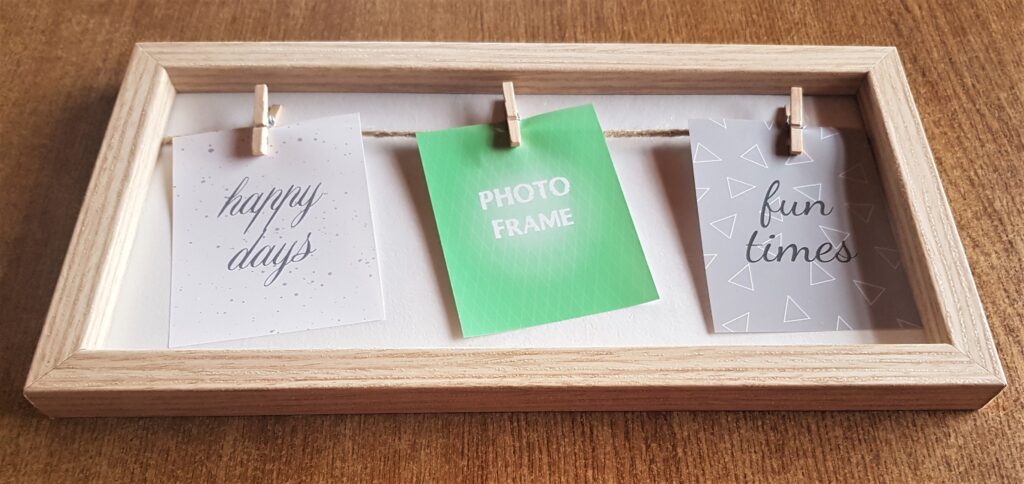 Light wood Frame with 3 pegs for photographs to display.