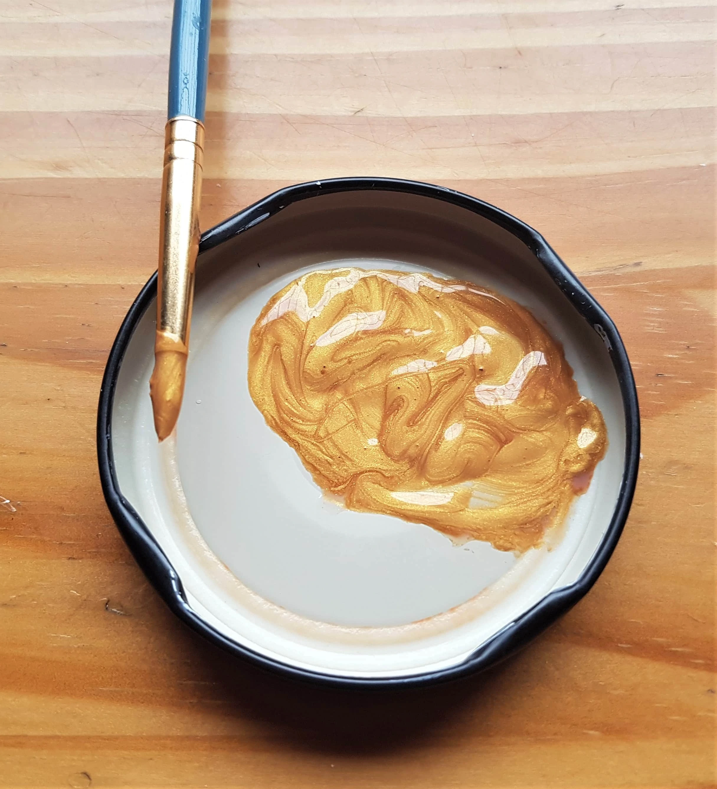Gold Paint in a Lid, I added water to it and mixed it together with a Paintbrush.