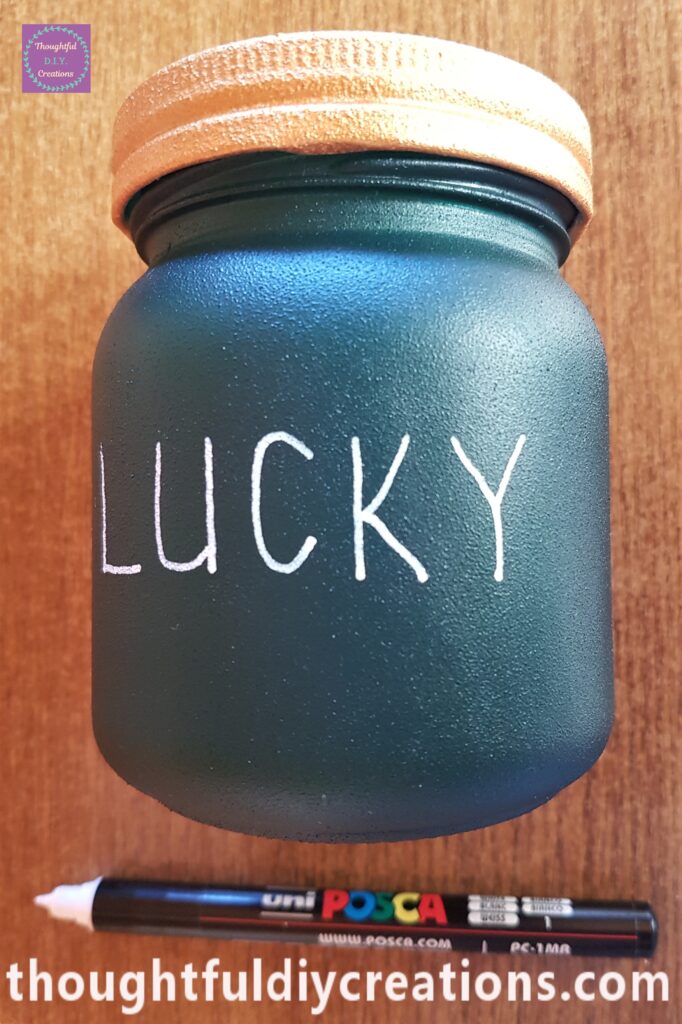 I got my 'White uni POSCA Acrylic Paint Pen 0.7mm' and wrote 'LUCKY' onto the first Paddy's Day Jar.