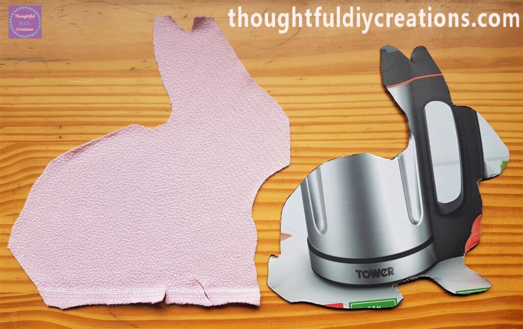 The back of the Pink Fleece after being Cut beside the back of the Cardboard Rabbit.