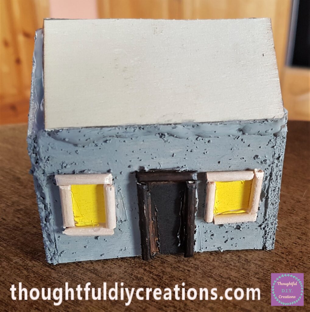 I Painted Gray Stone Paint onto the Fairy Cottage. I used a Paint Pen in Yellow to Paint the inside of the Windows and Brown Acrylic Paint to Paint the Door and Frame.