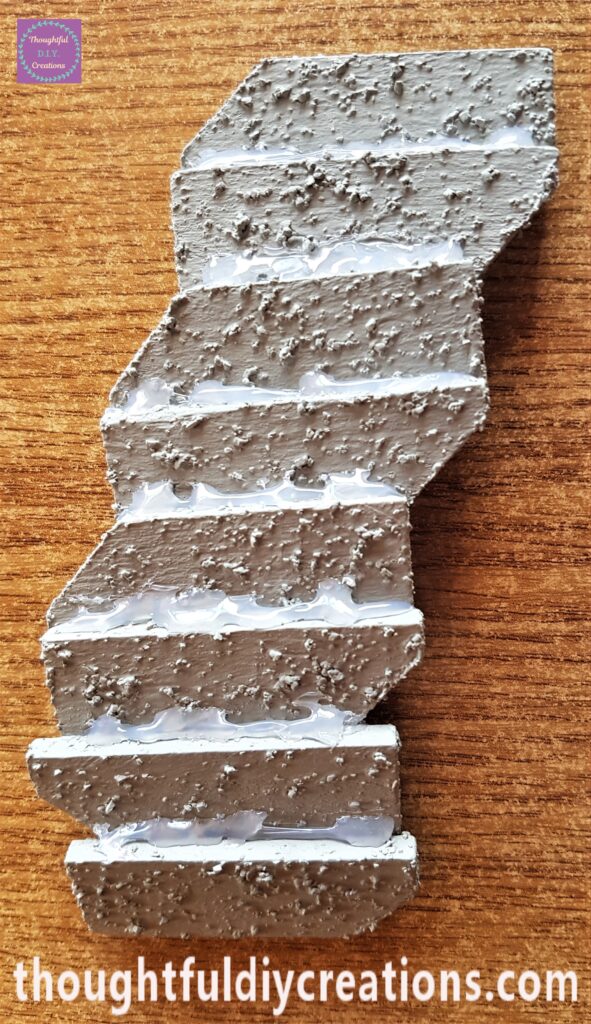 I Hot Glued the bottom edge of one piece to the top edge of the next piece until they were all attached together.