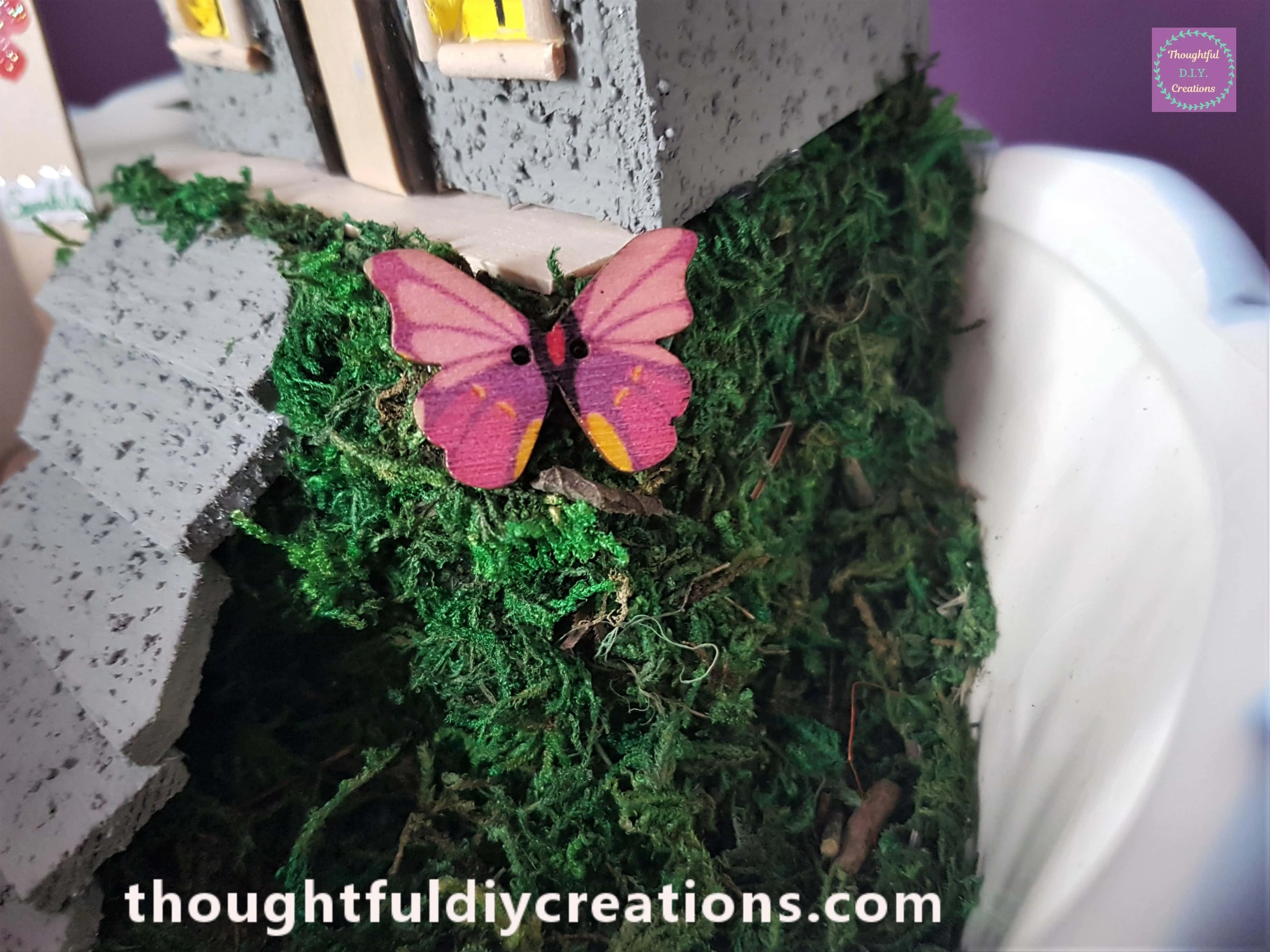 A Pink Wooden Butterfly was Glued to the edge of the Hill.
