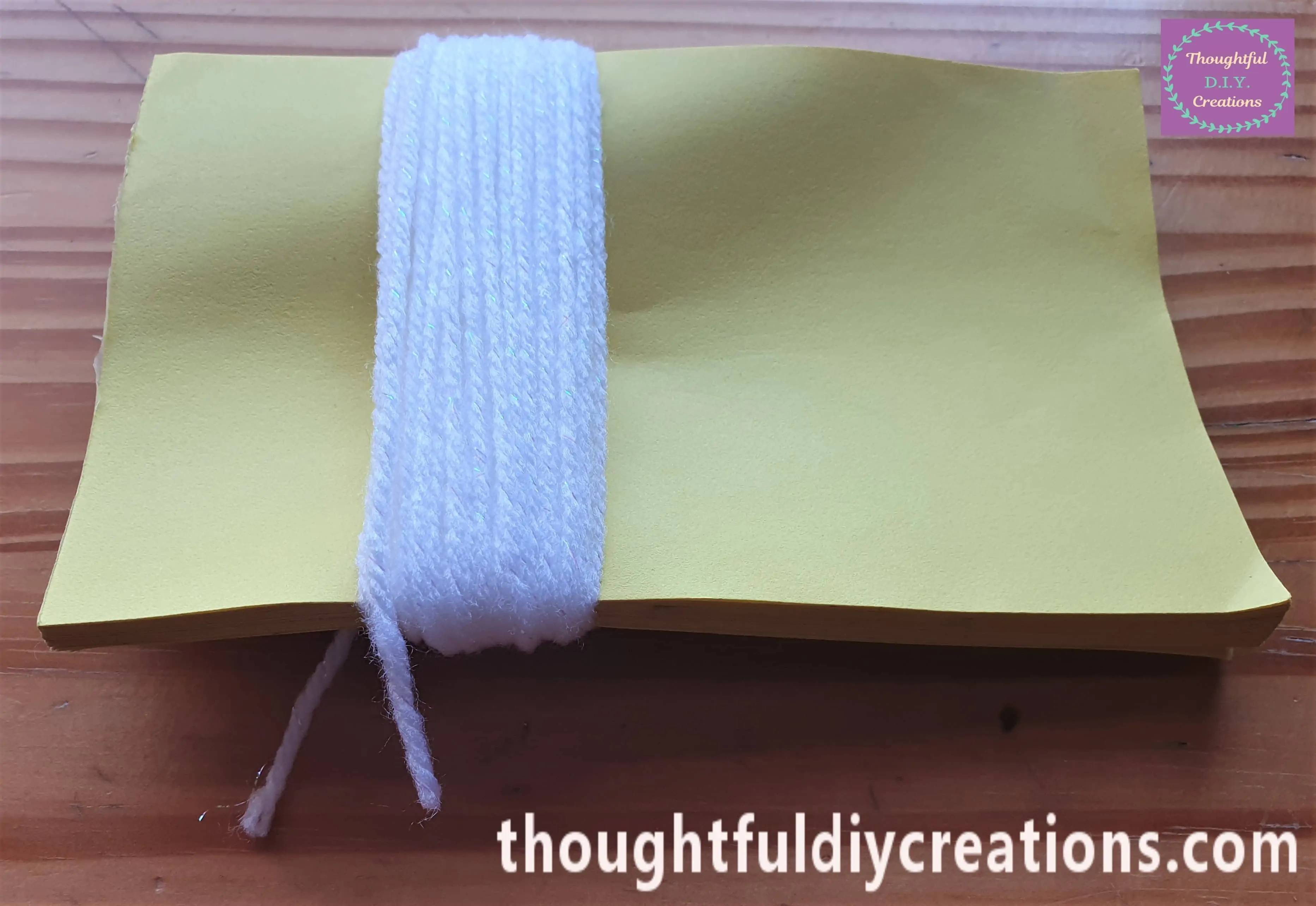 I wrapped the Wool around the Notepad 50 times. I Cut the end of the Wool slightly longer like the first piece.