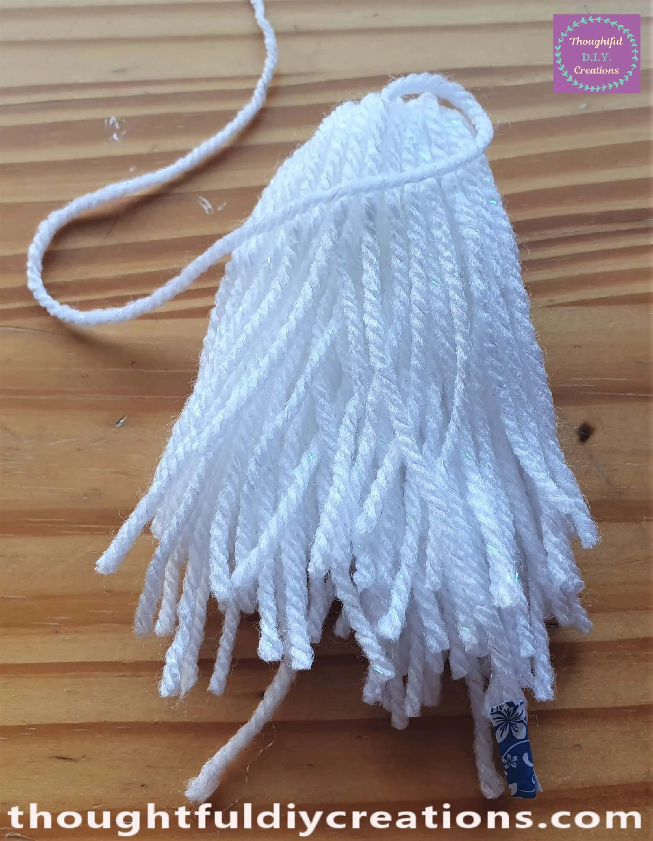 I moved this end of string with the loop on top of the bundle of wool.