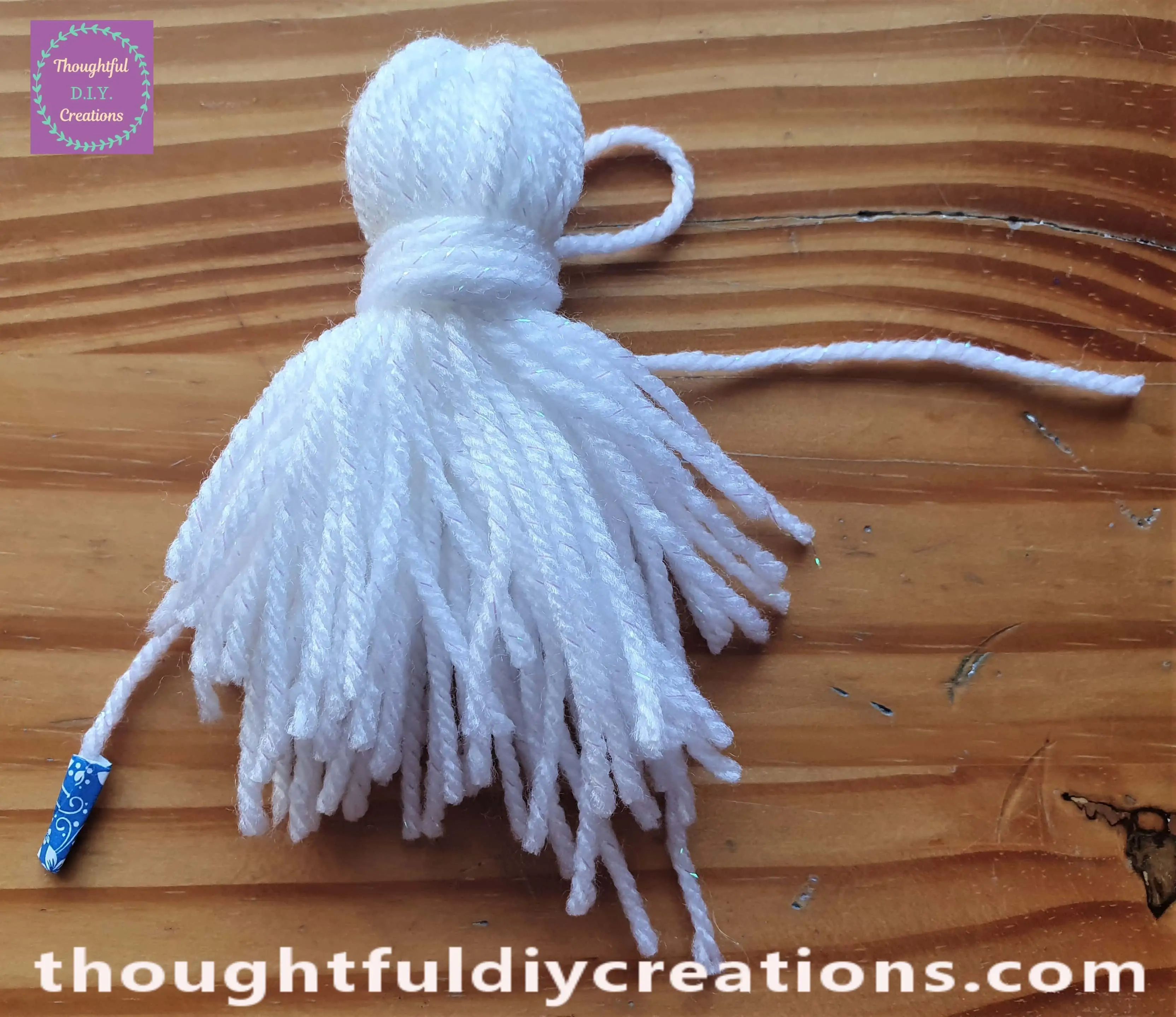 I wrapped the wool around a couple more times. I cut the end of the wool. This is the front of the tassel with the loop peaking behind.