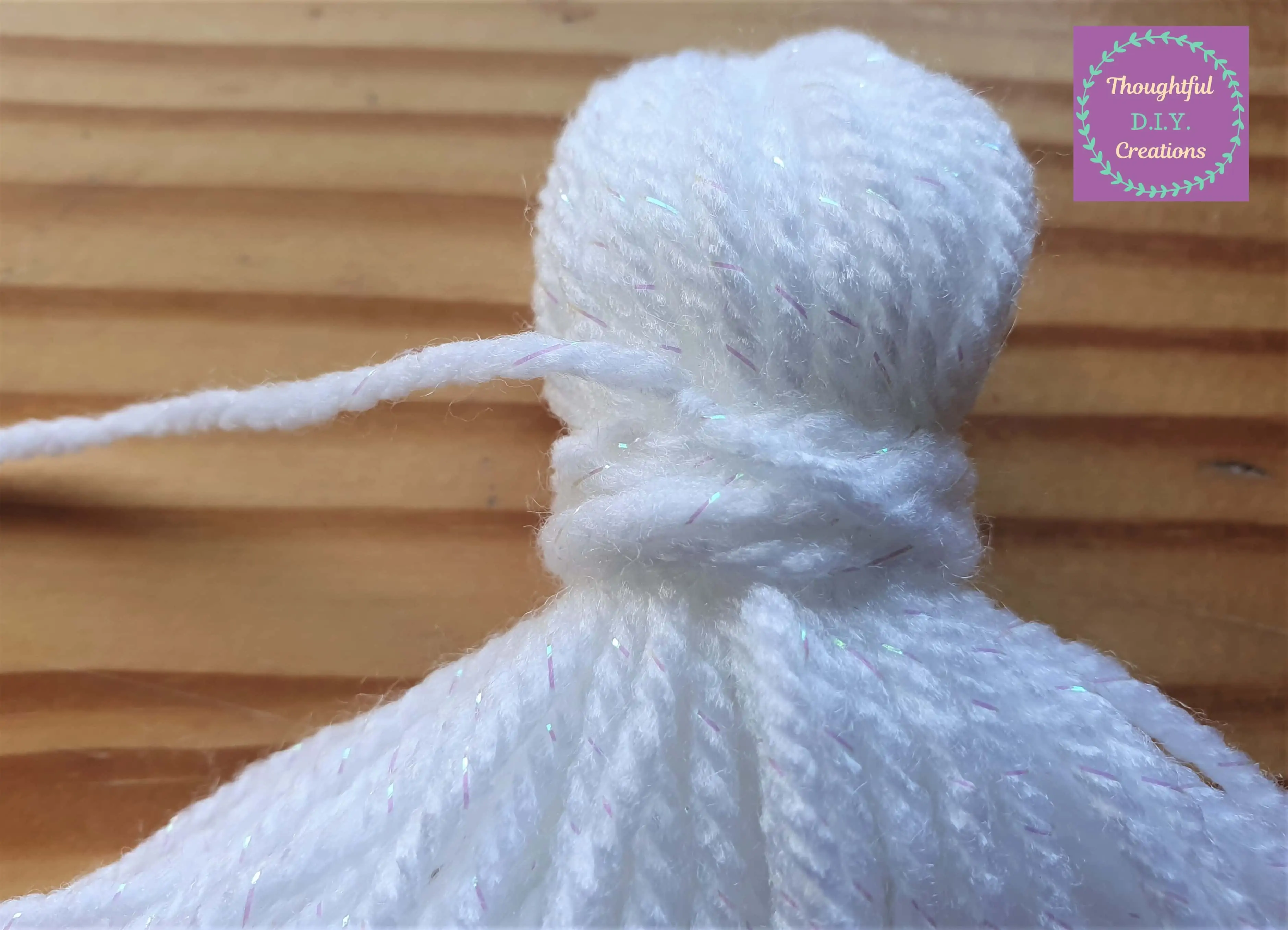 As I pulled the string with washi-tape down, the other end of string put through the loop tightened into the loop forming a knot.