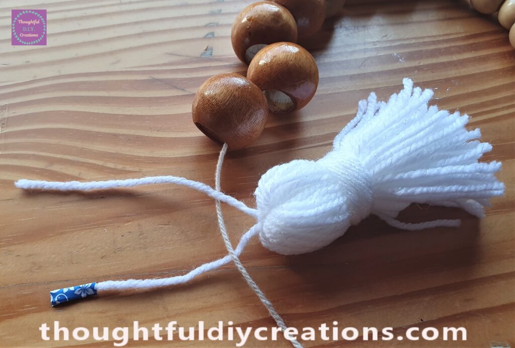 I put the String with washi-tape underneath the cream string of the wooden bead garland, and put the other white string over the cream string.