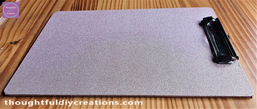 I attached a few strips of clear glue to the back of the clip and held it onto the top of the Clipboard.