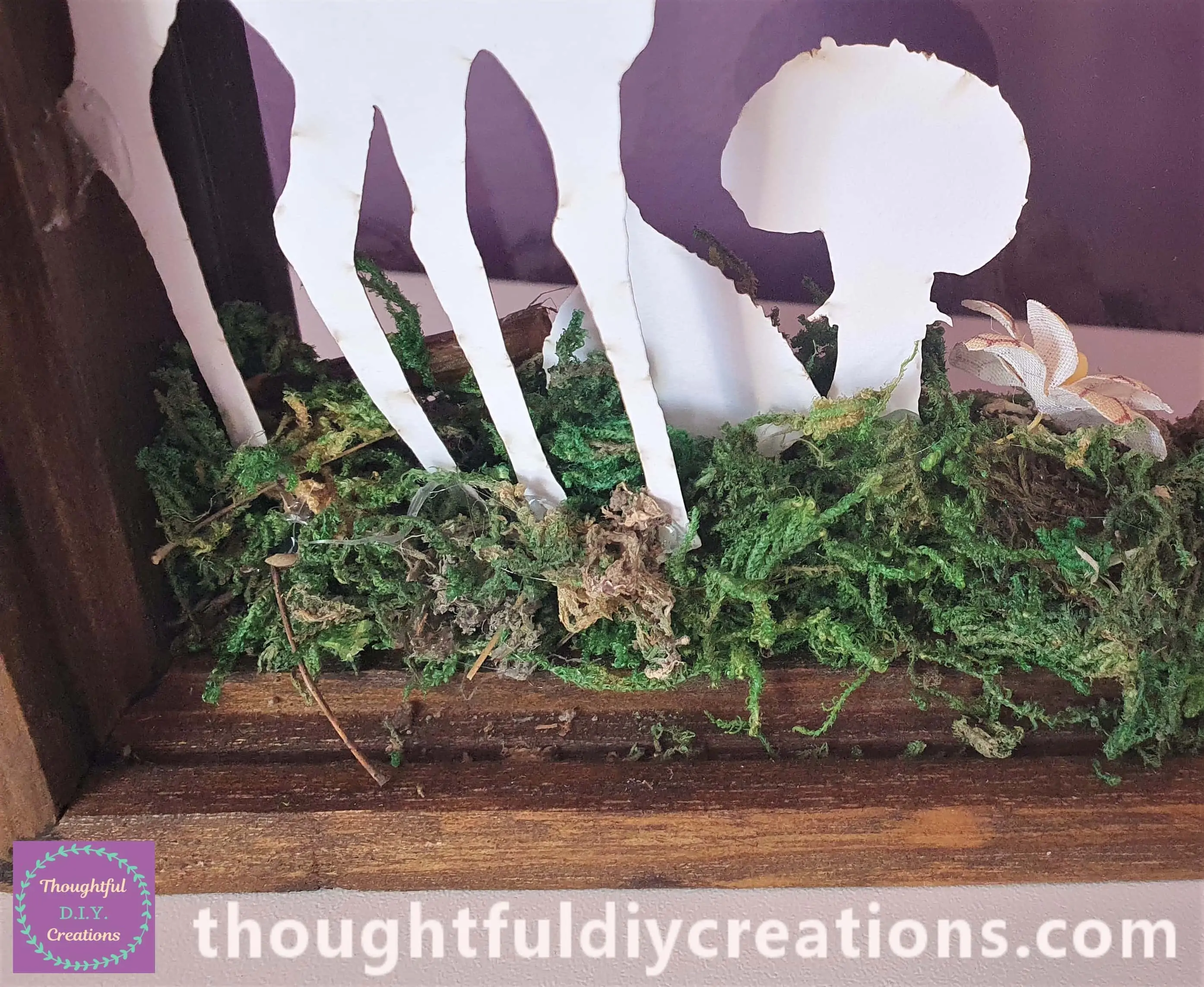 I placed a branch and yellow flower into the front of the Frame. I hot glued a Mushroom and a Leaf beside the Deer.