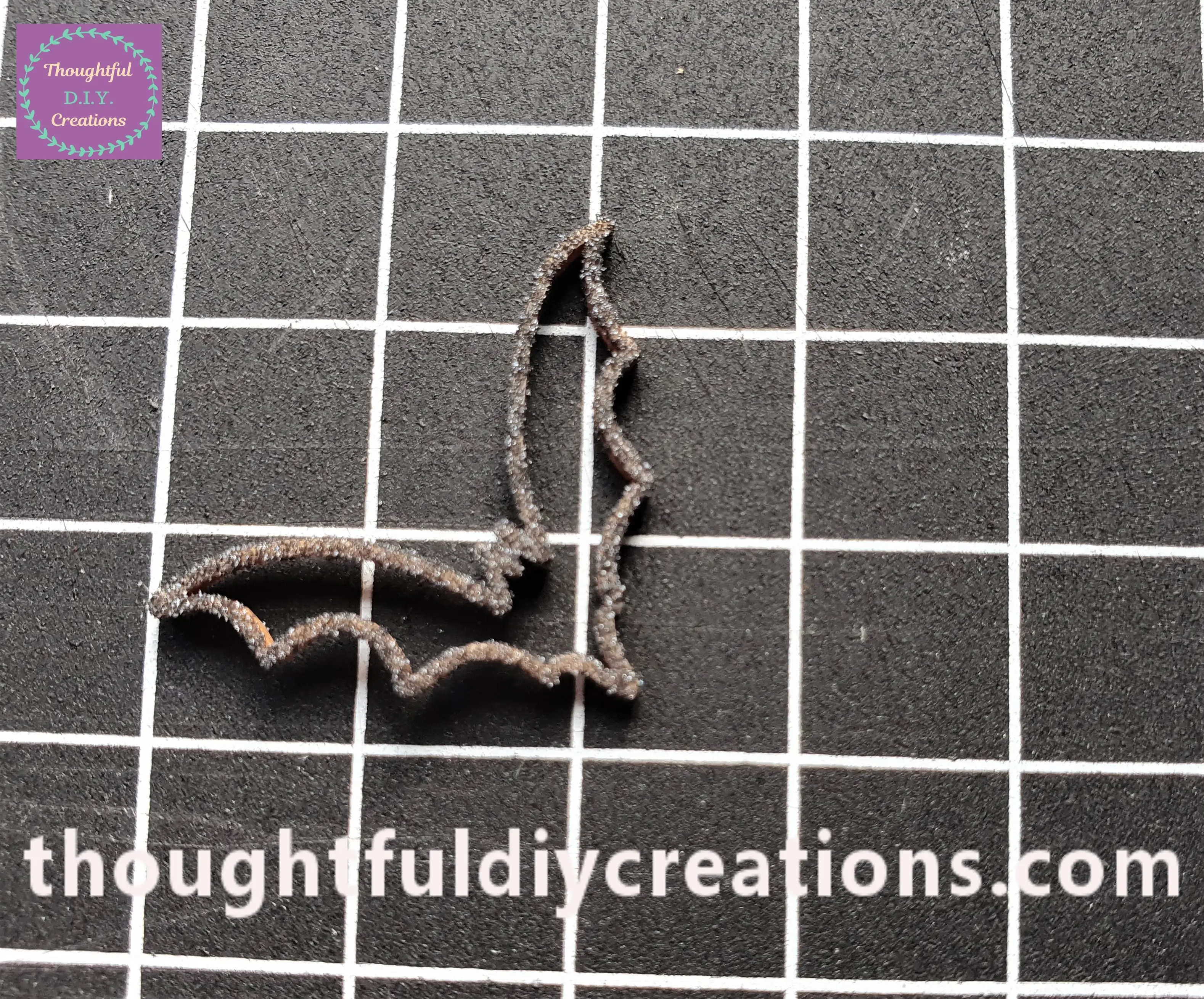 I picked up the Bat with the tweezers and placed it on a Mat. This is how the Bat looks with the Embossing Powder attached to the Ink.